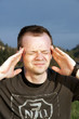 Portrait of a man with hands on temples