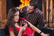 Young couple in love enjoying wine near fireplace Young couple in love enjoying wine near fireplace