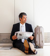 Business man sitting on the floor waiting with baggage