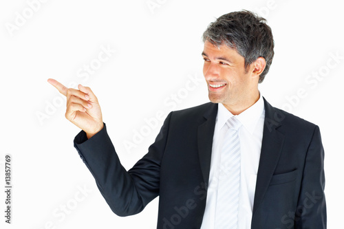 Photo: Attractive business man pointing at copyspace Attractive business man pointing at copyspace