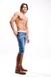 Fashion shot of a Young Man in jeans and boots. Denuded torso