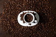 White cup with coffee beans, view from above