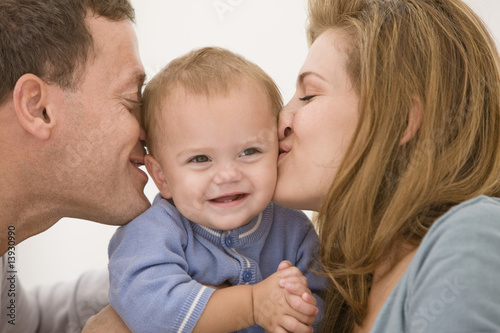Photo: Parents kissing their daughter Parents kissing their daughter