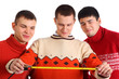 Three young men look on tape measure