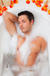 attractive man relaxing in foamy bath