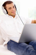 Young woman sitting on couch and working on laptop