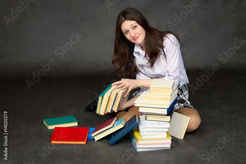 Photo: Schoolgirl with the big heap of books Schoolgirl with the big heap of books
