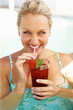 Beautiful woman enjoying a drink in the pool