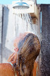 Woman washing hair under shower