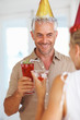 Happy mature male having fun in a birthday party