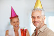 An aged cheerful man having fun in a birthday party