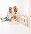 Portrait of a happy older couple at breakfast table