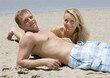 An attractive couple laying on the beach