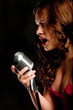 Beautiful singer singing with microphone