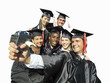 Graduates in caps and gowns taking photograph of themselves, cut out