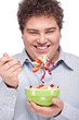 Happy young chubby man with fresh salad in dish, isolate