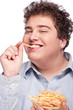 Happy young chubby man with pommes frites in dish, isolate