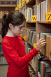 Young girl in library looking for books