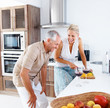 Happy senior couple preparing food in the kitchen Happy senior couple preparing food in the kitchen