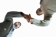 Two businessmen shaking hands, upward view, cut out