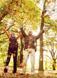 A senior couple throwing autumn leaves in the air