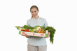 woman holding crate of fruit and vegetables, cut out