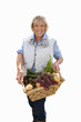 senior woman holding basket of vegetables, cut out