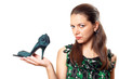 woman with shoes heel in one hand and sandals in another.