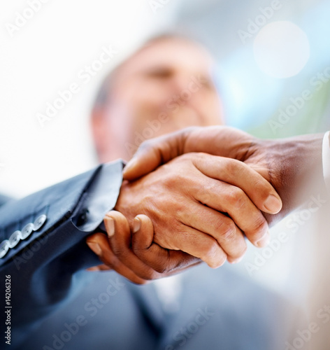 Foto: Closeup: Business men shaking hands over a deal Closeup: Business men shaking hands over a deal