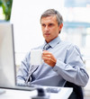 A business man drinking coffee while looking at the computer
