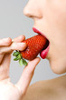 Photo: closeup of a woman biting a strawberry closeup of a woman biting a strawberry