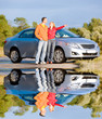 Happy young couple with their new car. Woman show something Happy young couple with their new car. Woman show something