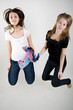 Blondi and  a brown-hair young girls jumping up