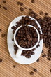 White cup with coffee beans on placemat