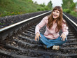 The young laughting girl sits on railway The young laughting girl sits on railway