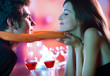 Young happy couple kissing in restaurant, celebrating Young happy couple kissing in restaurant, celebrating