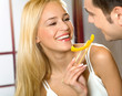 Young happy smiling couple eating playfully vegetable