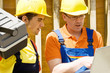 Foto: Zwei Bauarbeiter bei der Arbeit Zwei Bauarbeiter bei der Arbeit