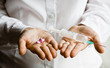 A doctor holding a handful of vitamin capsules and syringe A doctor holding a handful of vitamin capsules and syringe