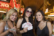 Photo: Portrait of three young women with playing cards and gambling chips in front of casino, Las Vegas, Nevada, USA Portrait of three young women with playing cards and gambling chips in front of casino, Las Vegas, Nevada, USA