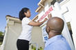 Couple putting up notice outside house