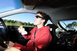 Man driving car while eating from bag