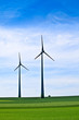 canvas print picture Wind turbines farm in green field over cloudy sky