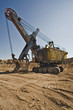 Rusty old yellow excavator on a sand