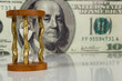 hourglass on big dollar background hourglass on big dollar background