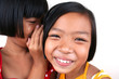 Two young asian kids whispering.