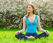 Beautiful young woman meditating outdoors