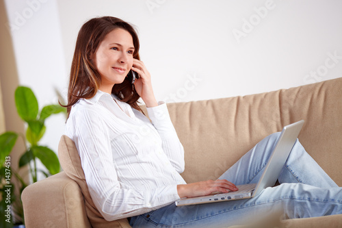 Foto: Frau mit Laptop beim telefonieren Frau mit Laptop beim telefonieren