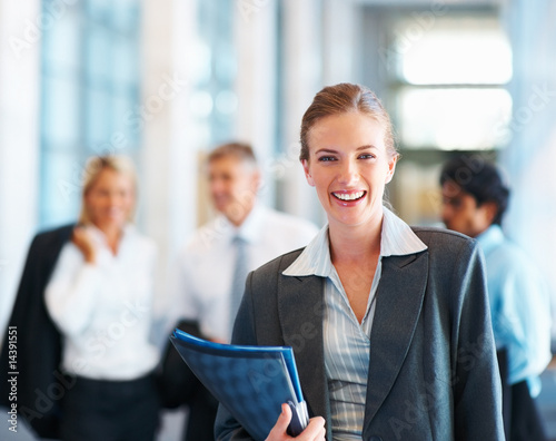 Photo: Pretty business woman, colleagues in the back Pretty business woman, colleagues in the back