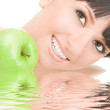 sweet girl eating green apple on white background